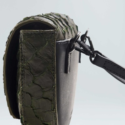 Mala pequena com textura verde escamosa e tecido cinza com alça preta