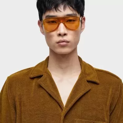 Óculos de sol com lentes laranja e camisa castanha texturizada com bolso