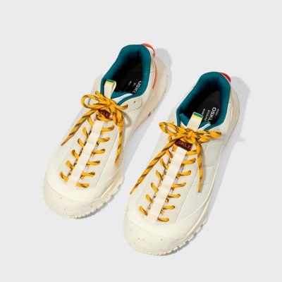 Ténis brancos com atacadores amarelos e detalhe vermelho e azul