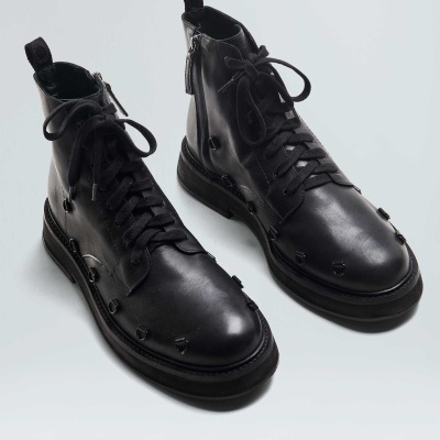 Botins pretos de couro com atacadores e zíper lateral com detalhes em rebites.