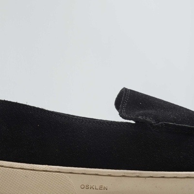 Tênis baixo preto com sola branca e marca OSKLEN na lateral da sola