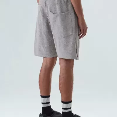 Calções masculinos cinzentos com bolso traseiro e cós elástico, vistos de trás