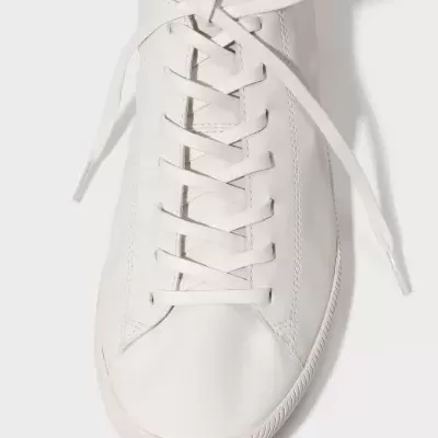 Tênis branco liso com atacadores e sola branca em fundo branco