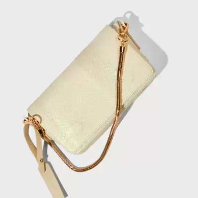 Carteira creme com corrente dourada, alça e fecho, sobre fundo branco