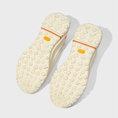 Solas de sapatilhas creme com textura antiderrapante e detalhes laranja