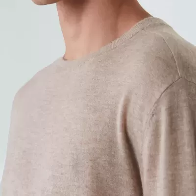 Camisola bege clara de malha com gola redonda vista de perto