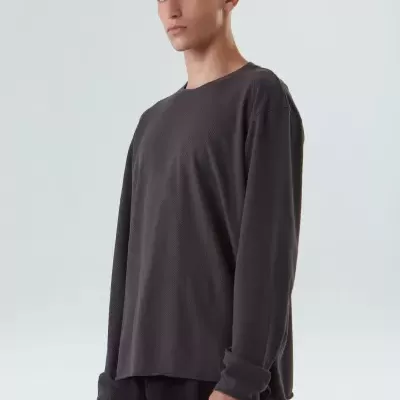 Homem com camisola preta de manga comprida em fundo branco