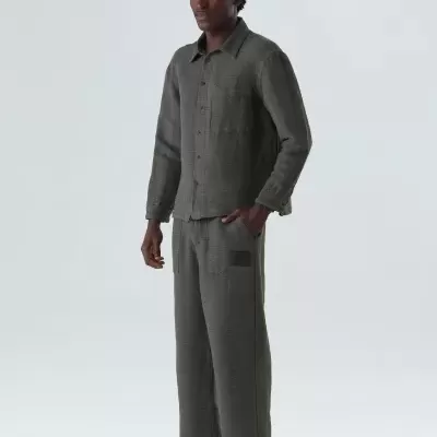 Homem vestindo fato cinzento texturizado composto por camisa e calças