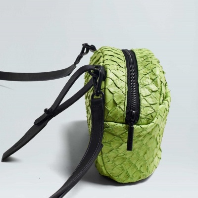 Bolsa pequena verde claro com textura de escamas e fecho preto