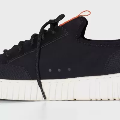 Ténis preto com sola branca e detalhe laranja no calcanhar