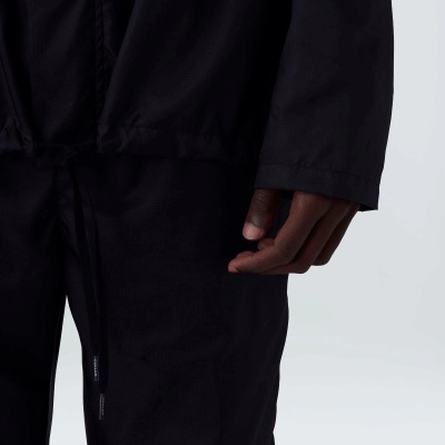 Detalhe de roupa preta de tecido leve com cordão na cintura