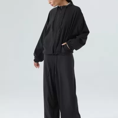 Conjunto preto de sweatshirt com capuz e calças largas em fundo branco