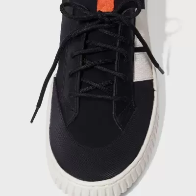 Ténis preto com sola branca e faixa laranja na língua