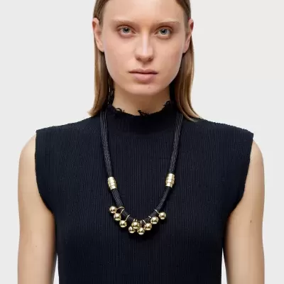 Colar preto com detalhes dourados e pendentes metálicos redondos