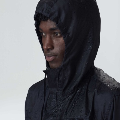 Casaco impermeável preto com capuz ajustável em modelo masculino