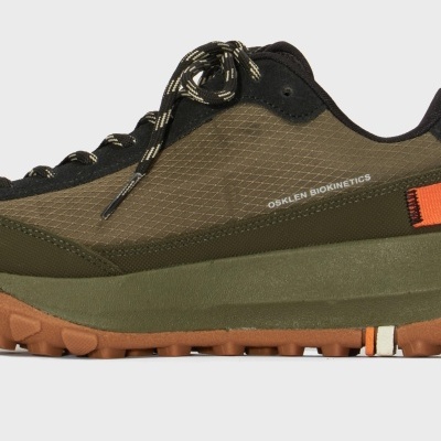 Ténis verde com sola castanha e atacadores pretos com riscas brancas