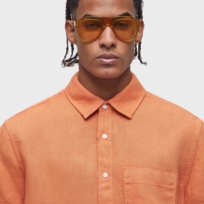 Camisa laranja de linho com bolso e óculos de sol amarelos