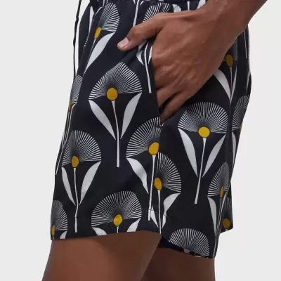 Calções masculinos pretos com padrão floral branco e amarelo e bolso lateral.