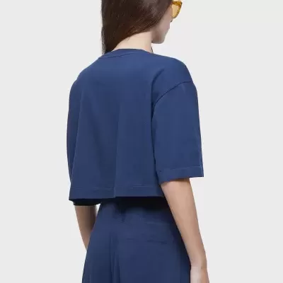 Mulher vista de costas a usar t-shirt cropped azul e calças largas azuis