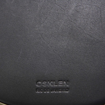 Produto de couro preto com inscrição OSKLEN RIO DE JANEIRO em relevo