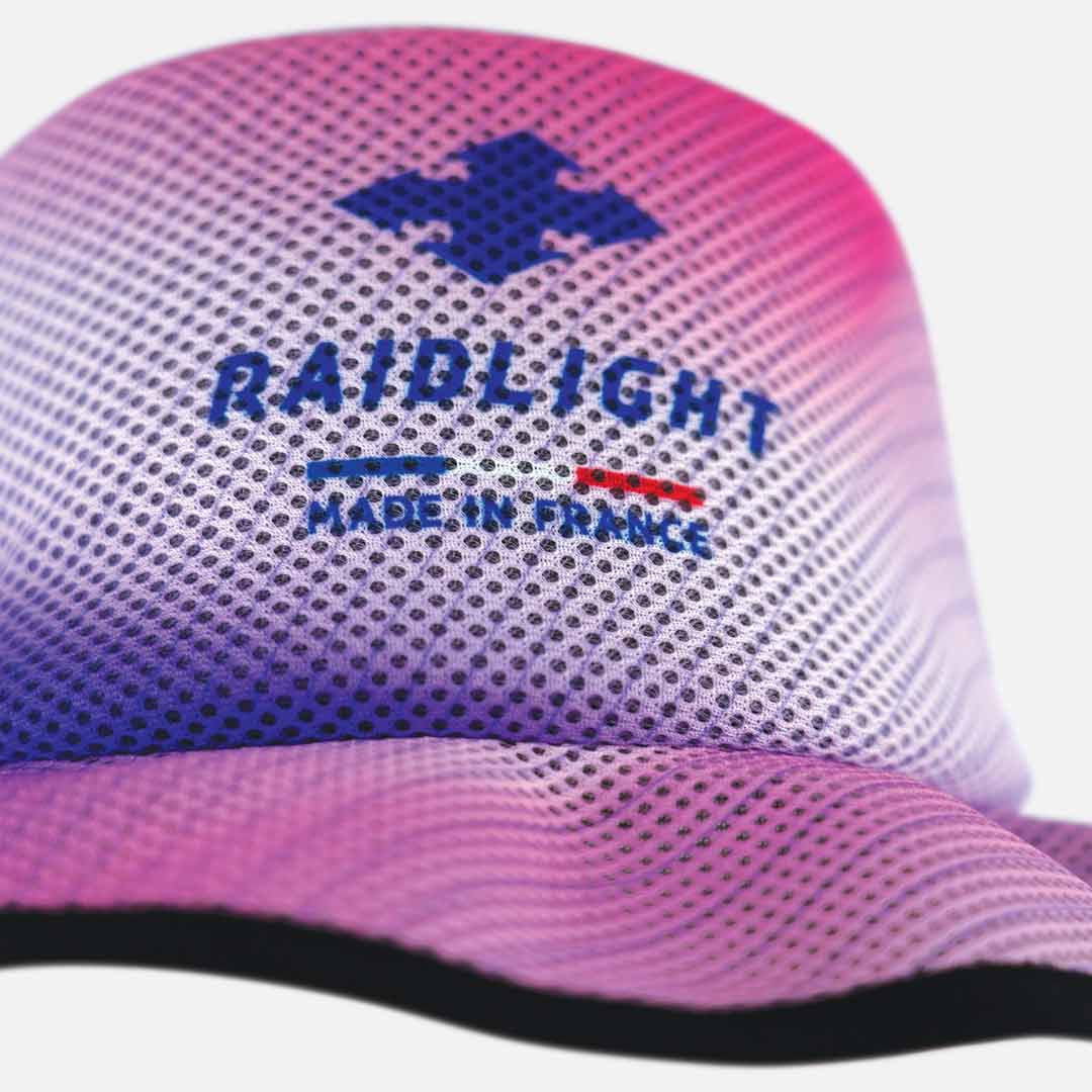 Boné desportivo com logótipo 'RAIDLIGHT MADE IN FRANCE' e padrão de pontos roxos e rosa