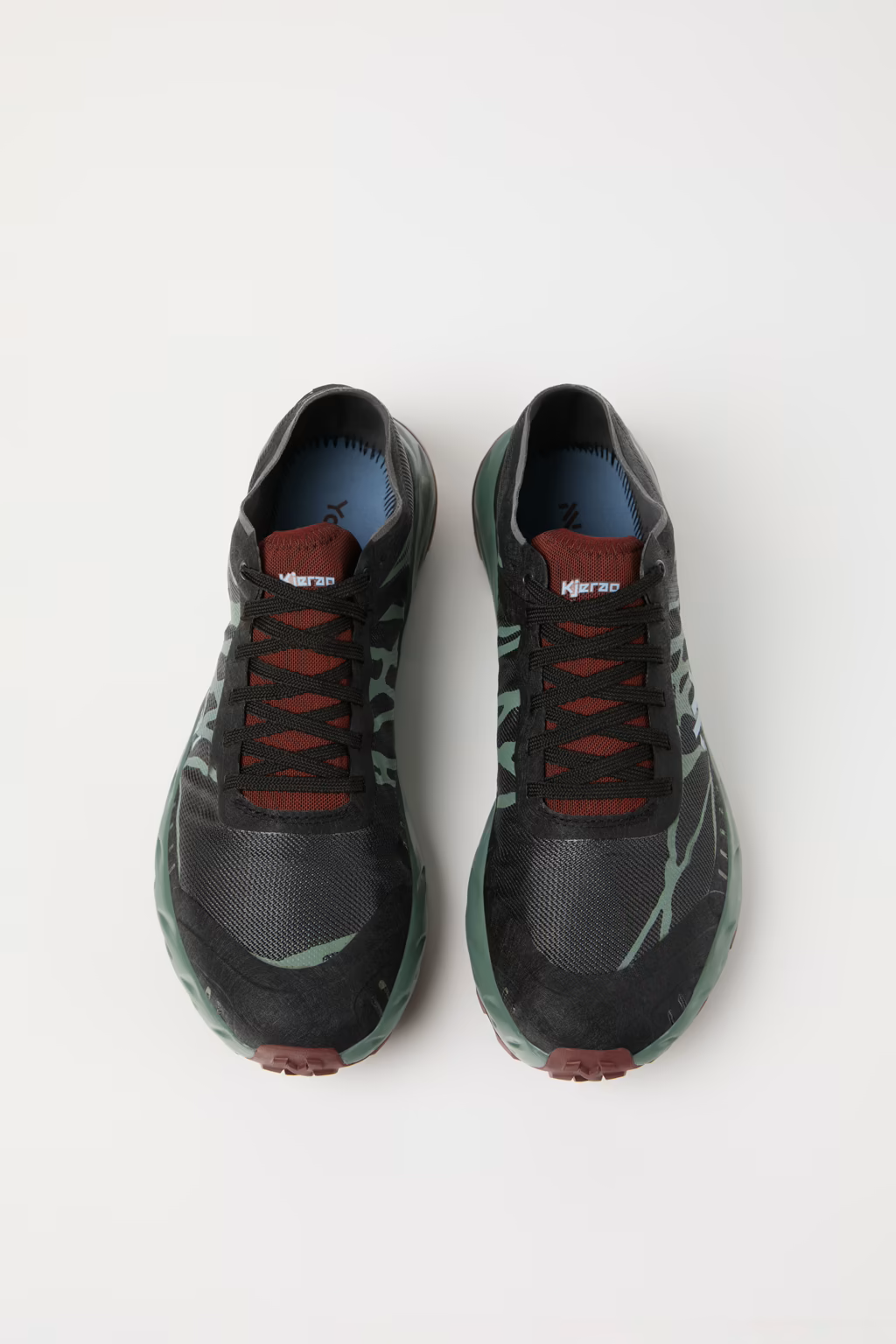 Par de sapatilhas desportivas pretas e verdes com atacadores castanhos