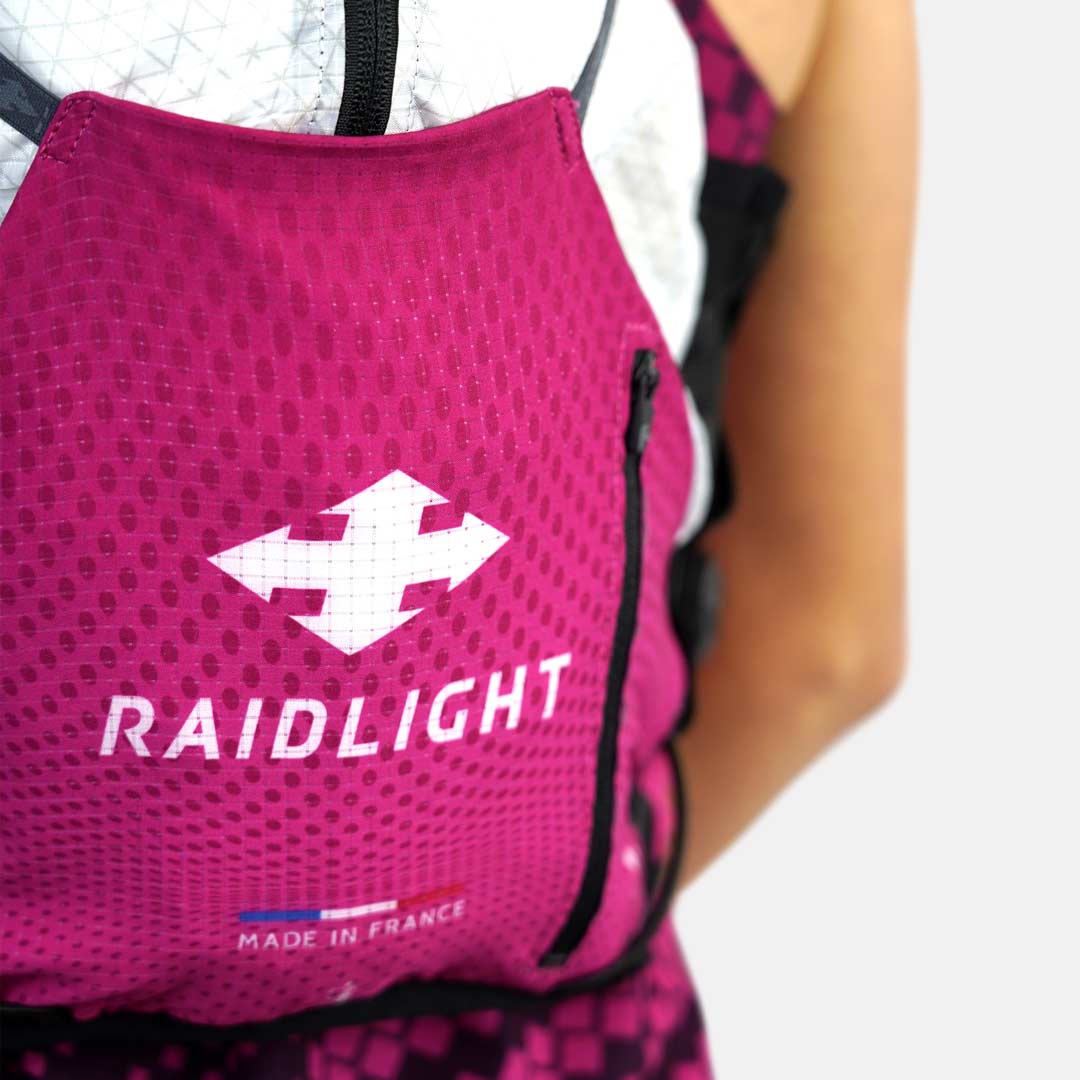 Mochila rosa com logo RAIDLIGHT e texto MADE IN FRANCE em roupa desportiva