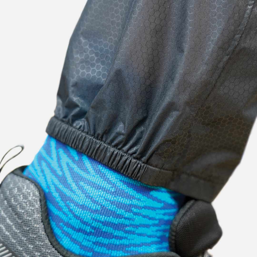 Braçadeira preta em tornozelo com meia azul e sapato cinzento