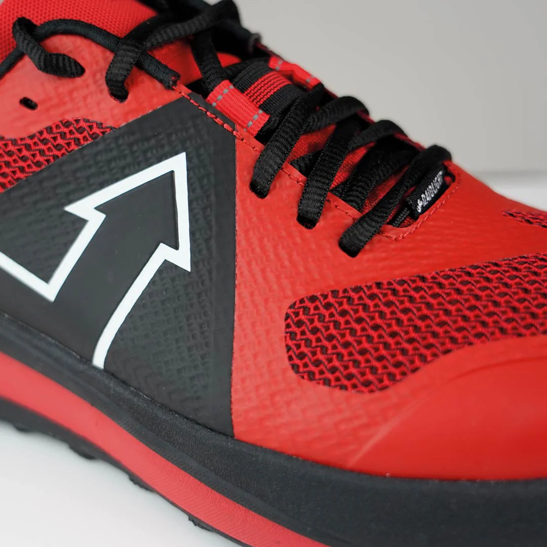 Tênis desportivo vermelho e preto com seta branca na lateral