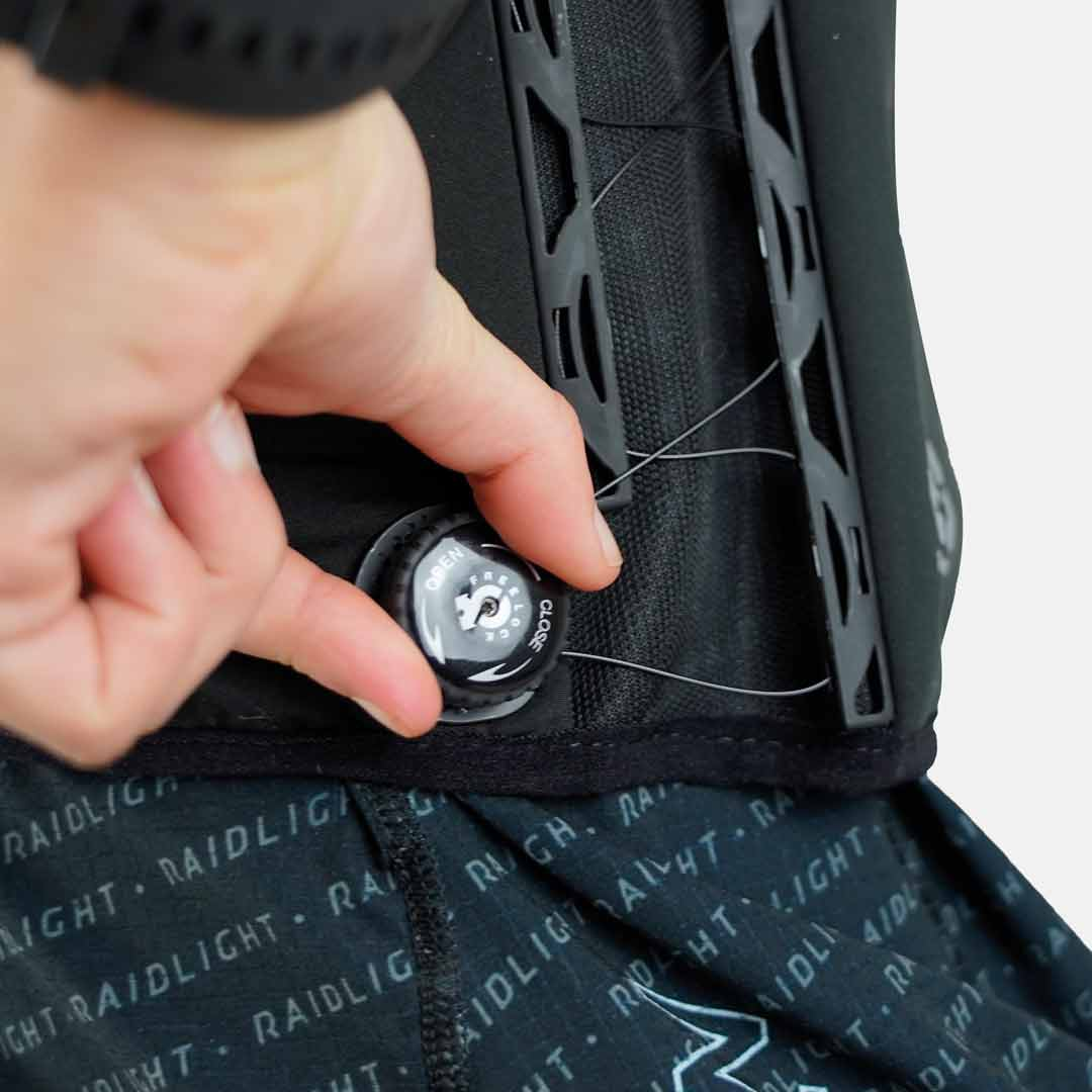 Mão a rodar botão de ajuste preto com texto OPEN CLOSE em equipamento têxtil Raidligh