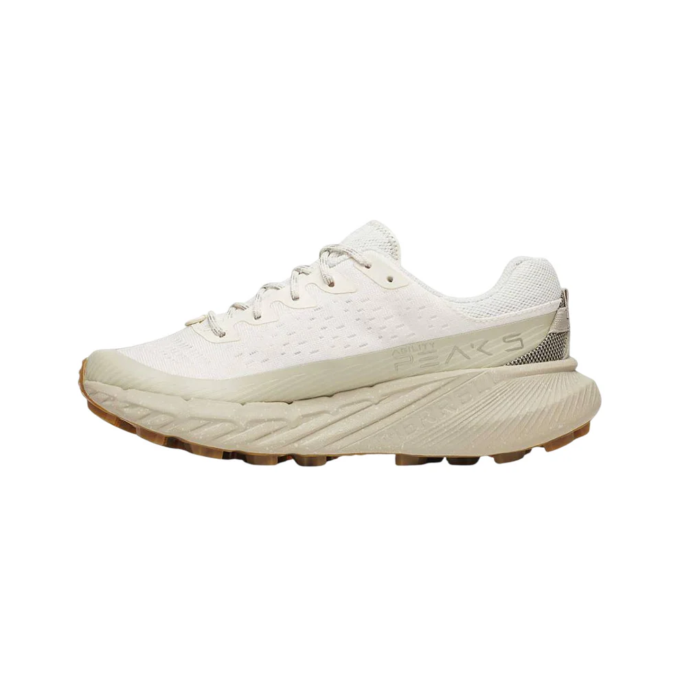 Ténis de corrida branco com sola bege e texto decorativo