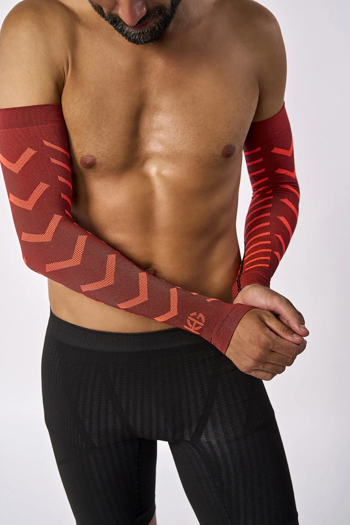 Homem a usar mangas compressivas vermelhas e calções pretos justos
