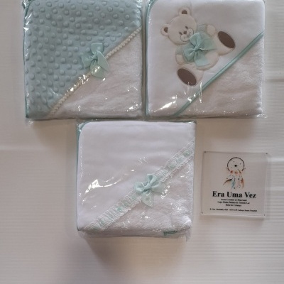 Três toalhas de bebé brancas e azul-acinzentado com detalhes e embaladas em plástico