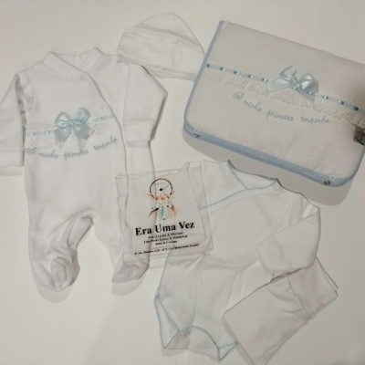 Conjunto de roupa de bebé branco com detalhes azuis e inscrição A minha primeira roupinha