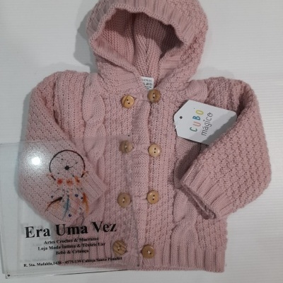 Casaquinho de malha rosa com capuz e botões de madeira sobre fundo branco