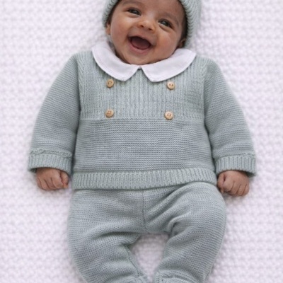 Bebé sorridente em roupa de malha cinza claro