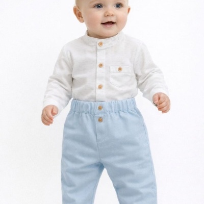Bebé com camisa branca e calças azuis claras, pé descalço