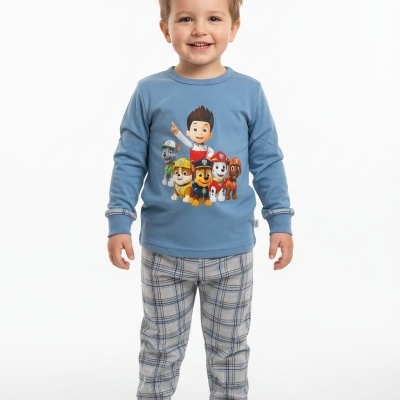 Criança a sorrir com pijama azul de Paw Patrol e calças xadrez