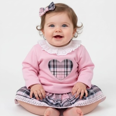 Bebé sorridente com roupa rosa e laço xadrez