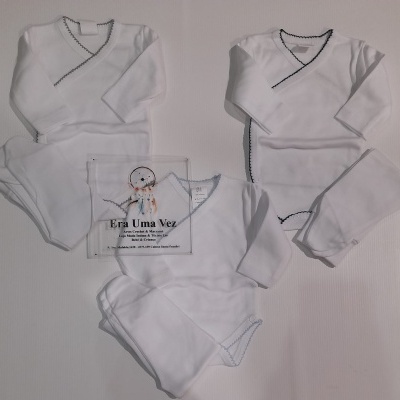 Conjunto de três fatos de bebé brancos com costura contrastante em fundo branco e placa promocional