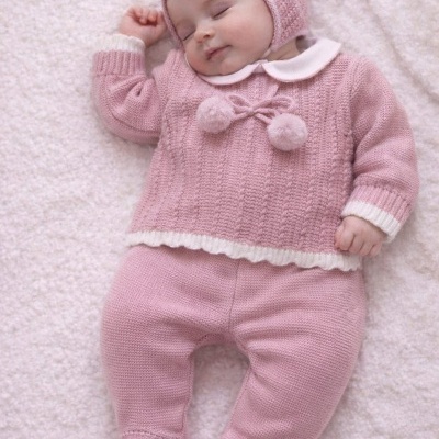 Bebé a dormir com roupa rosa em malha com gorro e pompons