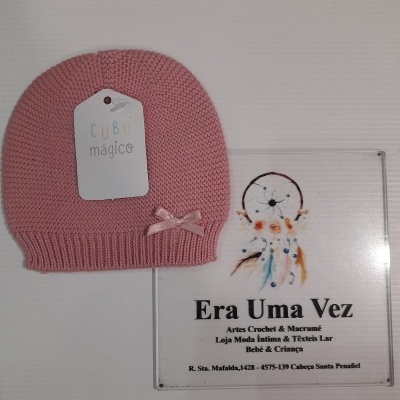 Gorro rosa de malha com laço e placa de loja com texto e imagem