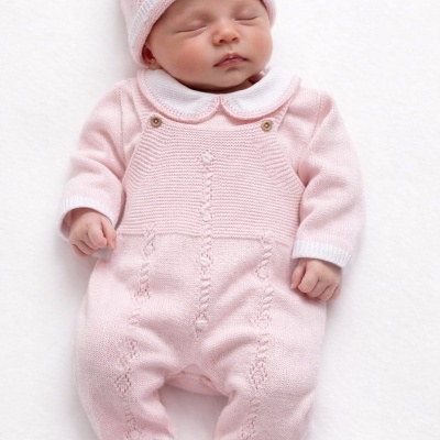 Bebé a dormir com fato de malha rosa e gorro