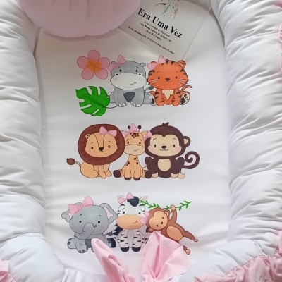Ninho de bebé branco e rosa com desenhos de animais da selva e etiqueta Era Uma Vez