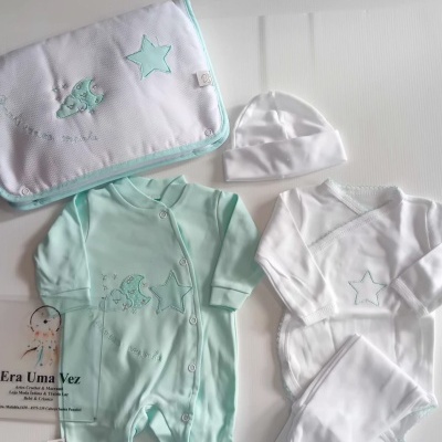 Conjunto de roupa de bebé com macacão verde-água, body branco, calças brancas, gorro branco e manta bordada