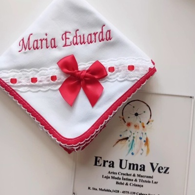 Fralda bordada com nome Maria Eduarda, laço vermelho e detalhes em renda