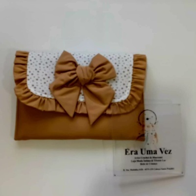 Bolsa de tecido castanho com laço e aba branca com pontos pretos