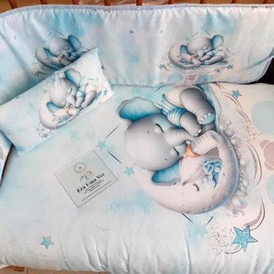 Edredão e almofada com elefante bebé azul em berço de madeira