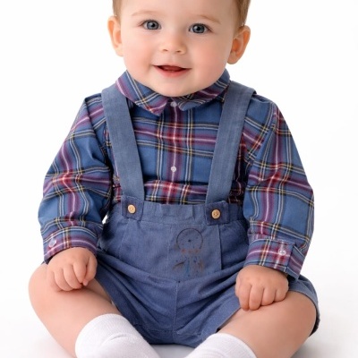 Bebé com roupa de criança xadrez e calções azuis sentado