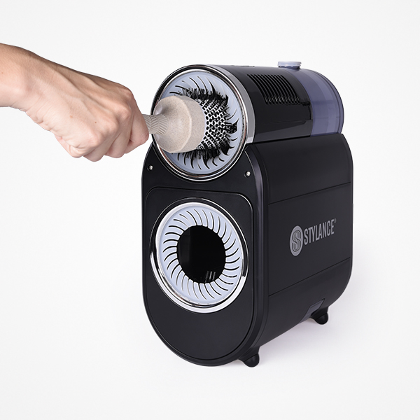 Máquina preta Styliance para limpeza de escovas com uma escova inserida